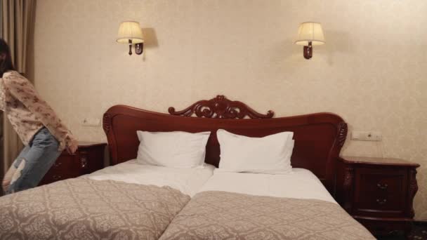 Happy woman falls in comfortable foam latex mattress bed luxury hotel enjoying — Stockvideo