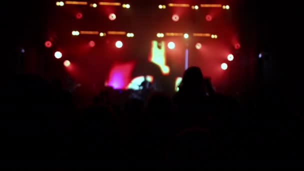 Vrolijke menigte op rock recital in de voorkant heldere lichten. Concertmaffia silhouetten — Stockvideo