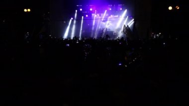 Rock konserindeki insanlar. Mutlu insanların siluetleri ellerini kaldırıyor.