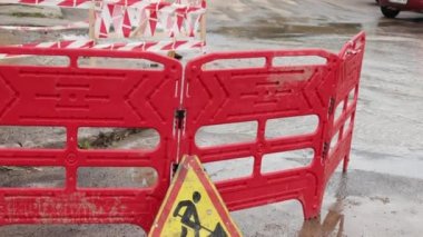 Trafik konilerinin yanında yol suyu fışkırır. Su birikintisi asfalta zarar veriyor. Kanalizasyon