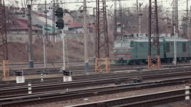 Tren istasyonunda elektrikli bir yolcu treni ile lokomotif. Eski lokomotif