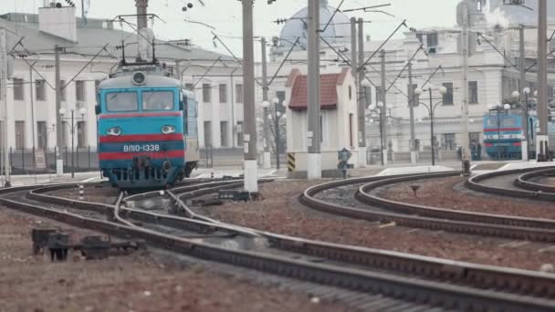 Локомотив с пассажирским электропоездом на вокзале. Старый локомотив — стоковое видео