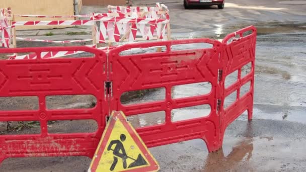 Straßen schütten neben Verkehrskegeln Wasser ab. Pfützen verursachen Schäden am Asphalt. Kanalisation — Stockvideo