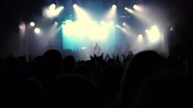 Rock konserindeki insanlar. Mutlu insanların siluetleri ellerini kaldırıyor.