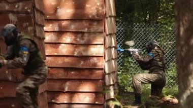 Koruyucu maske takan paintball oyuncusu. Üniformalı oyuncu