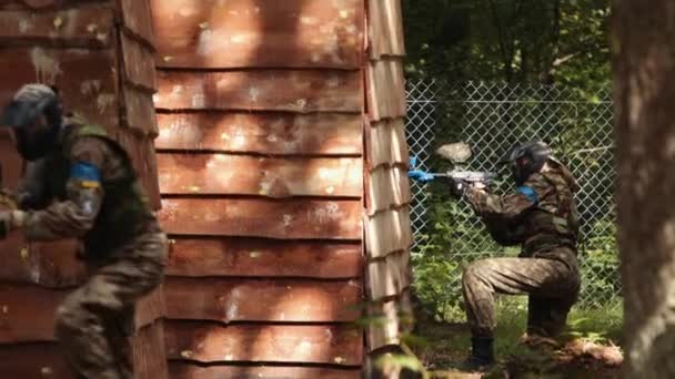 Paintball sportowiec noszenie maski ochronnej strzelanie. Gracz w mundurze — Wideo stockowe