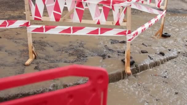 하수 처리, 수력 보드. 도로에서 물이 새는 곳 근처의 위험 한 국경. 도로에 물 이 세차게 흐르다 — 비디오