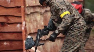 Paintball oynayın, silahlı oyuncular. Üniformalı ve maskeli ressamlar.