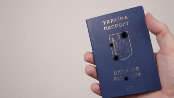 Ουκρανικό διαβατήριο που κατέχεται από άνδρες χέρι. Τρύπες στο έγγραφο από πυροβολισμούς. Πόλεμος — Αρχείο Βίντεο