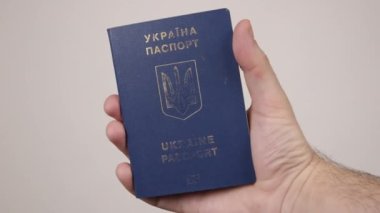 Elinde bir belge tutan Ukraynalı bir erkeğin mavi pasaportu. Turizm kavramı