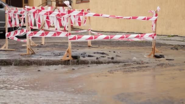 도로는 교통 혼잡 지역을 따라 물을 뿜습니다. 아스팔트에 손상을 입히는 흙탕물. 수련자들 — 비디오