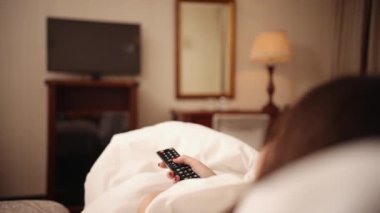 Sıradan bir kız elinde kumandayla televizyon programından zevk alıyor. Rahat yaşam