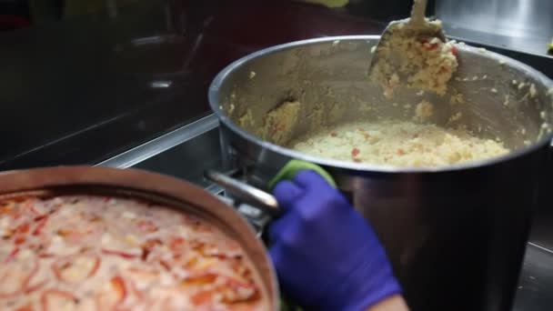 Mão masculina mistura prato, processo de cozinhar mingau de arroz guisado com legumes. — Vídeo de Stock