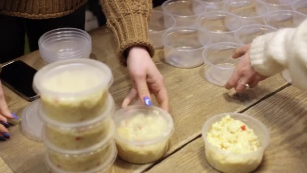 Frauenhände bereiten Schalen mit Reisbrei zu, um Obdachlosen zu helfen. Viele Gerichte. — Stockvideo