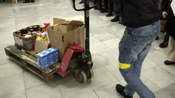 Voluntário masculino entrega carga em carrinho para centro de logística para ajudar soldados — Vídeo de Stock