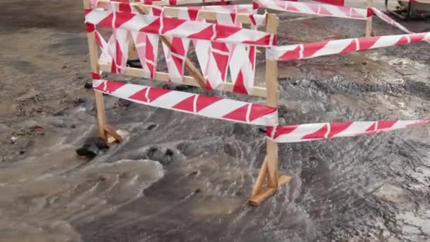 Wegspurt water naast verkeerskegels. Puddle veroorzaakt schade aan asfalt. Riolering — Stockvideo