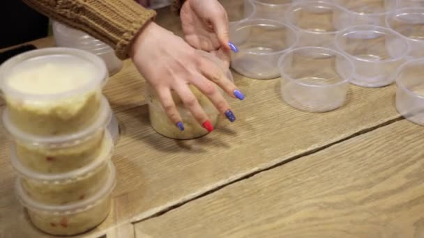 Close-up van vrouwenhanden die veel kommen rijstpap maken om mensen te voeden — Stockvideo