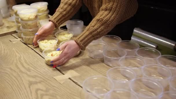 Close-up de mãos de mulheres fazendo muitas tigelas de mingau de arroz para alimentar as pessoas — Vídeo de Stock