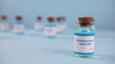 Şırınga iğnesi, bir damla sıvı, mavi arka planda bulanık pfizer şirketi..