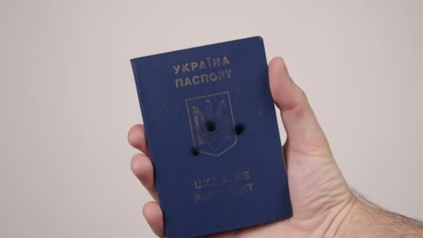 Ukrajinský pas v držení lidí rukou. Díry v dokumentu ze střelby. Válka — Stock video