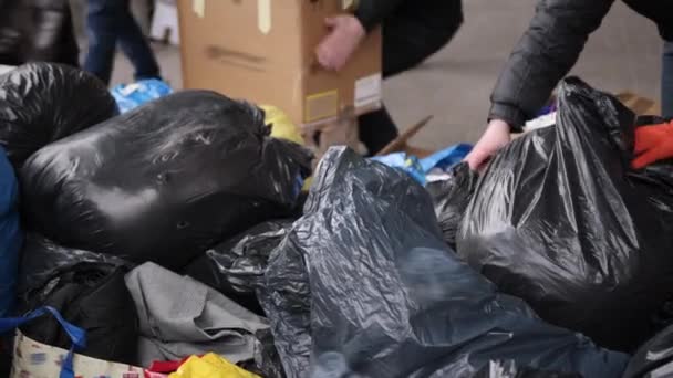 Mãos masculinas voluntários para ajudar as pessoas deslocadas com roupas, alimentos — Vídeo de Stock