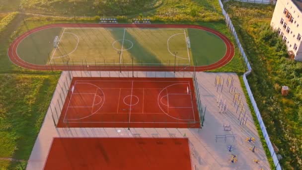Bâtiment scolaire et cour d'école le matin. Basketball aire de jeux département arbre. Aire de jeux — Video