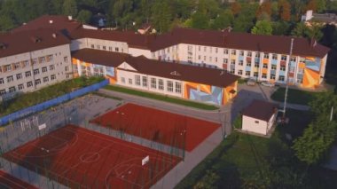 Yeşil çimenli okul. Devlet okulu binası. Oyun parkı olan binanın dışı..