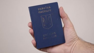 Elinde bir belge tutan Ukraynalı bir erkeğin mavi pasaportu. Turizm kavramı