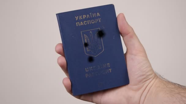 Passeport ukrainien détenu par mans main. Des trous dans le document provenant de coups de feu. Guerre — Video