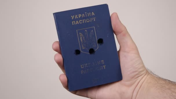 Ukrainian passport held by mans hand. Holes in the document from gunshots. War — Stock Video