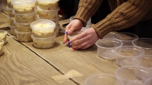妇女的手准备了几碗米粥来帮助无家可归的人。很多菜. — 图库视频影像
