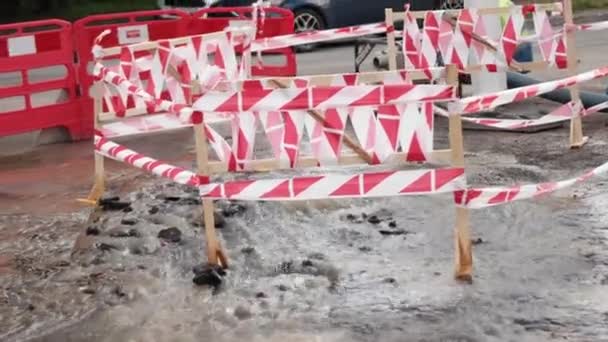 Estrada jorrar água ao lado de cones de tráfego. Pudim causando danos ao asfalto. Esgotos — Vídeo de Stock