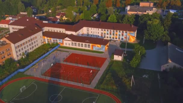 Cour de l'école avec verdure et un terrain de sport pour le basket-ball et les sports. — Video