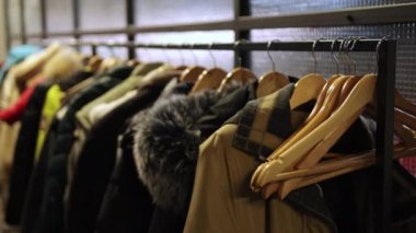 Birçok insan ceketi askılarda, ön planda boş askılarda asılı. Dolap.
