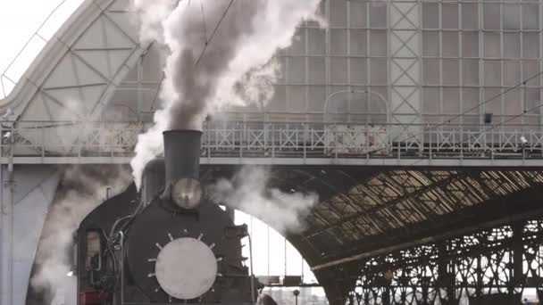 Retro steam train departs from the railway station. Old black steam train with blue cars — Stock Video