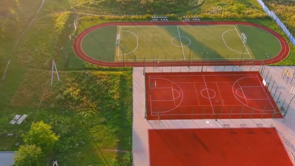 Edificio escolar y patio escolar. Entrenamientos deporte activo juego de baloncesto contra la ciudad de fondo — Vídeo de stock