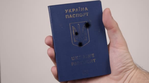 우크라이나 여권은 만스가 손으로 쥐고 있다. 보고서에 총에 맞은 흔적 이 있어. 전쟁 — 비디오