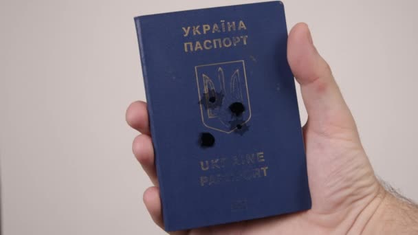 Mans hand holds passport Ukraine shot with bullets. Concept of war in Russia — Stock Video