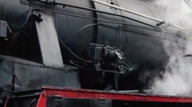 Antika buharlı tren lokomotifi. Çift lokomotif treni duman sızdırıyor, arkadan buhar çıkıyor..