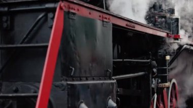 Treni kaplayan duman. Retro buharlı lokomotif tren istasyonundan ayrılıyor. Eski siyah buhar treni