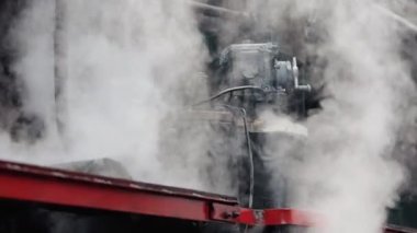 Treni kaplayan duman. Retro buharlı lokomotif tren istasyonundan ayrılıyor. Eski siyah buhar treni