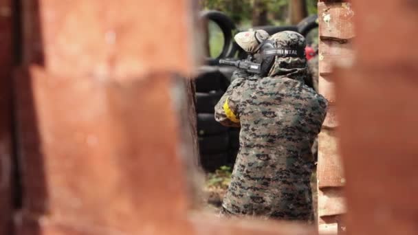 De alta qualidade. Jogador de esporte Paintball usa máscara protetora apontando arma. Arma de tiro — Vídeo de Stock