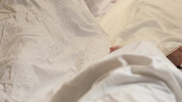 Um cadáver humano coberto com um lençol no quarto. Cadáver de homem coberto. Morte dos jovens — Vídeo de Stock
