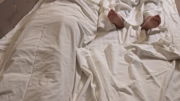 Um cadáver humano coberto com um lençol no quarto. Cadáver de homem coberto. Morte dos jovens — Vídeo de Stock