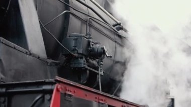 Antika buharlı tren lokomotifi. Çift lokomotif treni duman sızdırıyor, arkadan buhar çıkıyor..