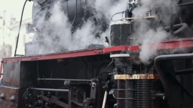 Antika buharlı tren lokomotifi. Çift lokomotif treni duman sızdırıyor, arkadan buhar çıkıyor..