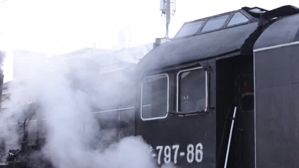 Comboio locomotivo a vapor que se aproxima da estação que passa pelo pátio de mercadorias — Vídeo de Stock