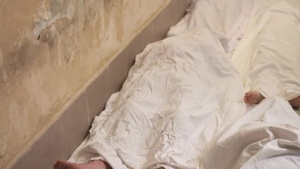 Human corpse covered with a sheet in room. Man corpse covered sheet. Young people death — 비디오