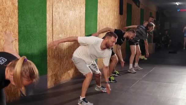 Uitrekken. Sport mannen stretching lichaam, springen buigen naar voren. Sportieve mensen — Stockvideo