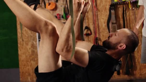 Fit jolie jeune homme faisant des exercices d'étirement de yoga de mouche avec trx sangles de fitness dans la formation de remise en forme — Video